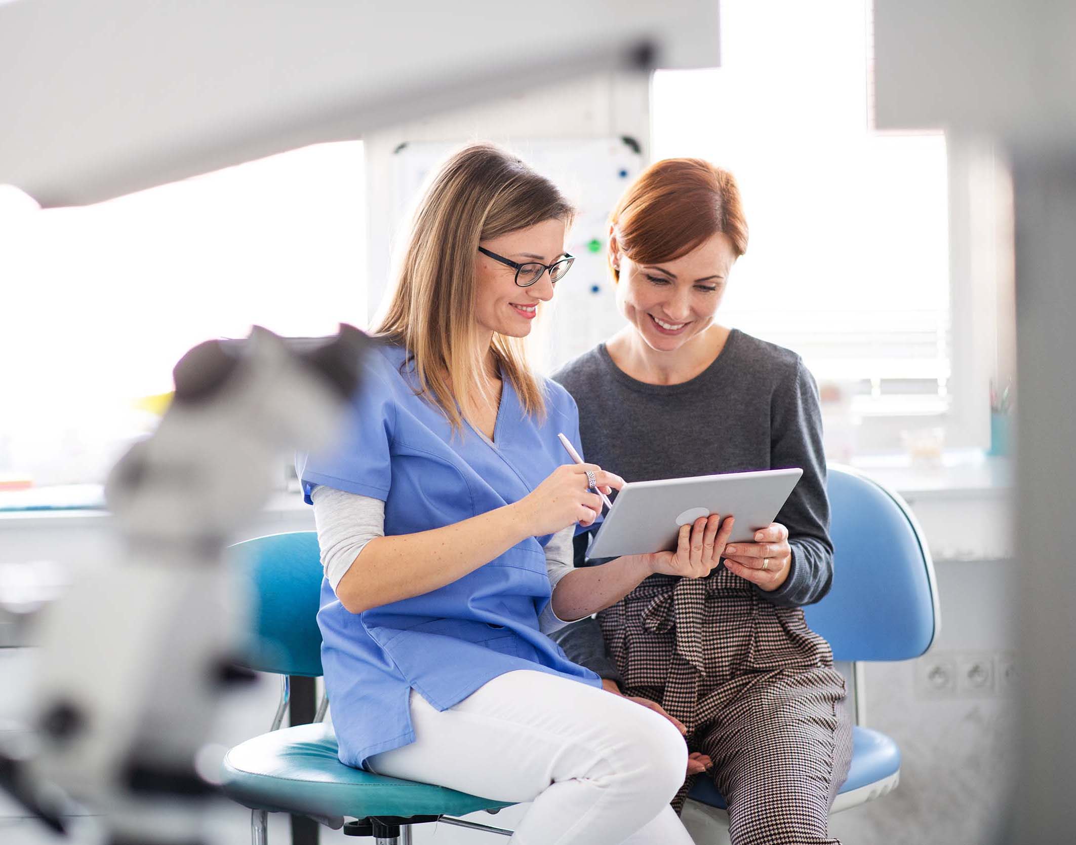 a dentist talking to woman in dentist surgery a d CMVQGB
